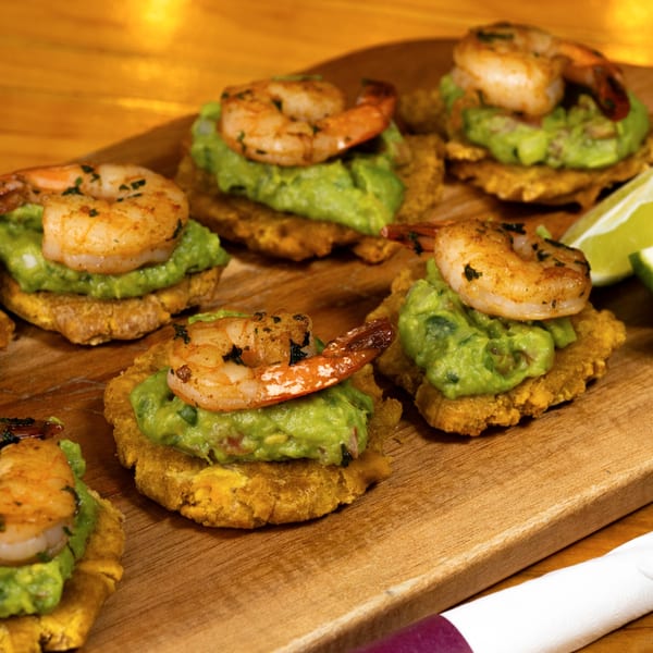 Shrimp and guacamole tostadas on a wooden board with lime wedges, from Agave Brunch Bistro Cafe.